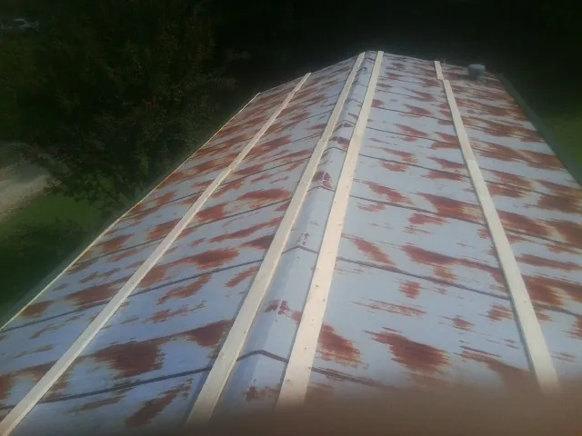 Rusted metal roof panels with new wood purlins before replacement — Storm Damage Roof Repair in Packwood by Roofing Brothers