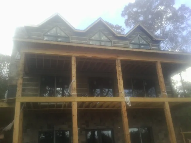Dormers and porch framing on a large log home under construction — Roof Coating work by our crew in Packwood