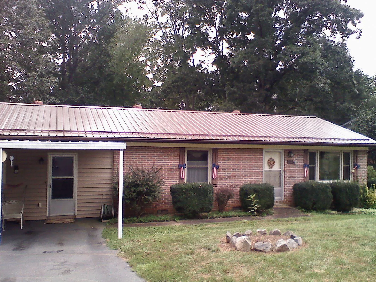 Bronze metal roof and carport on a brick ranch home — Roof Repair work by our crew in Packwood
